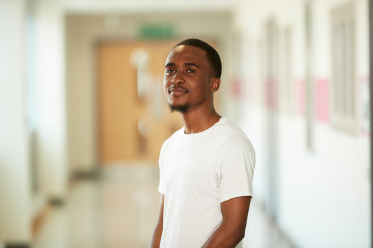 Portrait confident young male college student in corridor