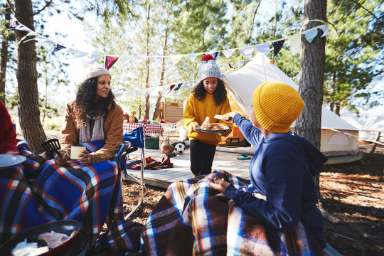 Family eating at campsite in woods