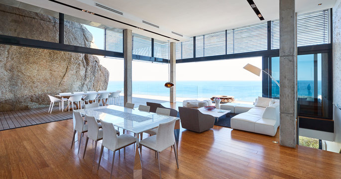 Modern luxury living room and dining room open to patio with ocean view