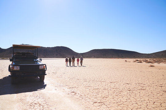 Safari tour group walking in sunny arid desert South Africa