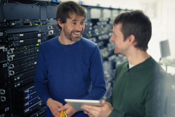 Server room technicians using digital tablet
