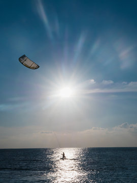 Parasailing on ocean under sunny blue sky