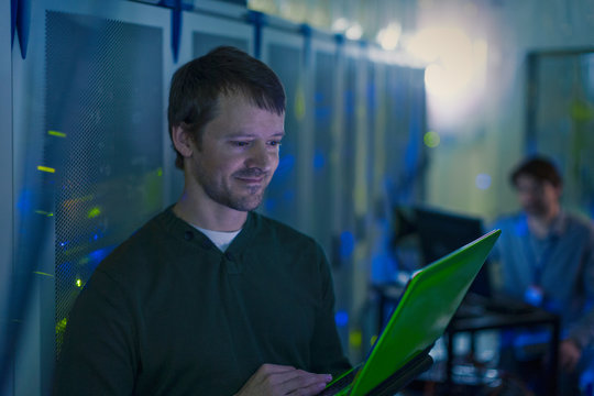 Server room technician using laptop