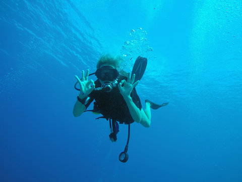 Portrait of confident scuba diver gesturing okay underwater