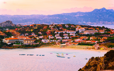 Fototapeta premium Landscape and scenery of Baja Sardinia luxury resort in at sunset evening, Sardegna island in Italy in summer. Olbia province. Villas And Mediterranean sea. Mixed media.