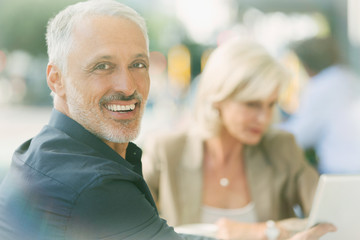 Portrait smiling businessman at sidewalk cafe