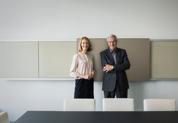 Portrait confident businessman and businesswoman in conference room