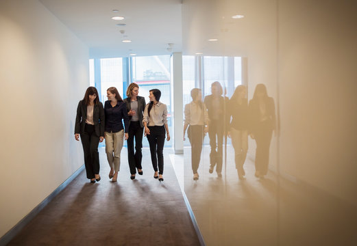 Businesswomen walking in a row in office corridor