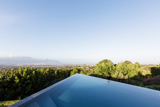 Modern, geometric infinity pool with sunny view under blue sky