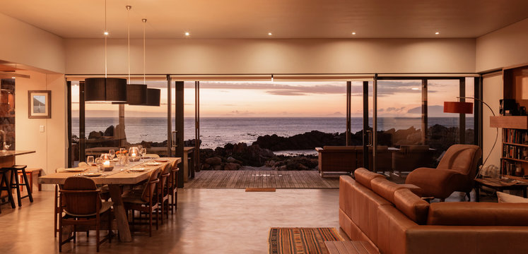 Home showcase interior overlooking ocean at sunset