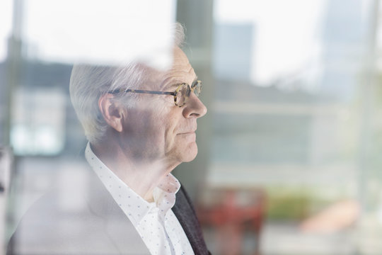 Pensive senior businessman looking out office window