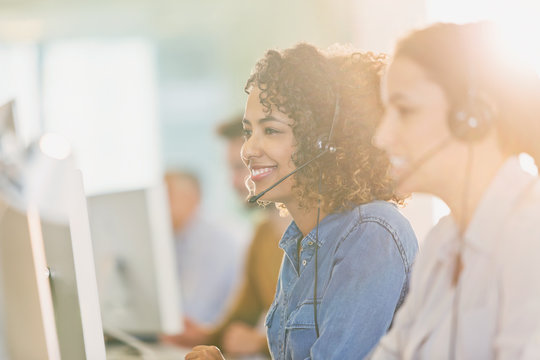 Businesswomen with headsets working at computers in office