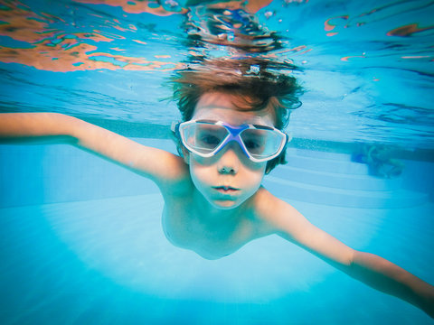 Portrait of boy swimming underwater in swimming pool