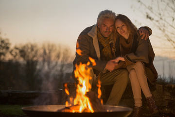 Affectionate serene couple enjoying autumn campfire
