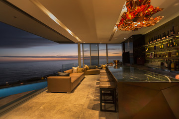 Twilight ocean view beyond luxury home showcase bar