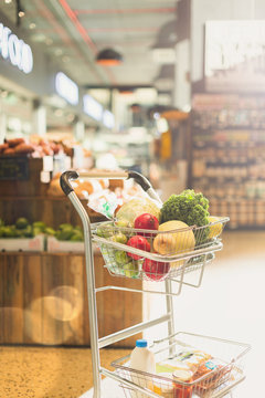 Produce and groceries in shopping cart in market