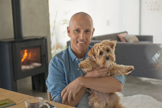 Portrait smiling mature man holding cute dog