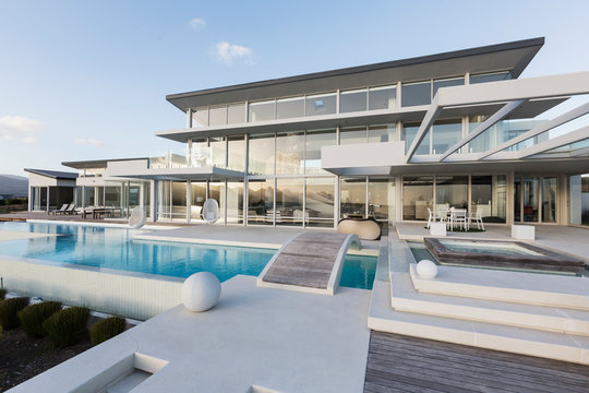 Tranquil modern luxury home showcase exterior with swimming pool and footbridge