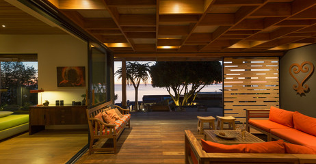 Illuminated modern, luxury home showcase interior living room open to patio