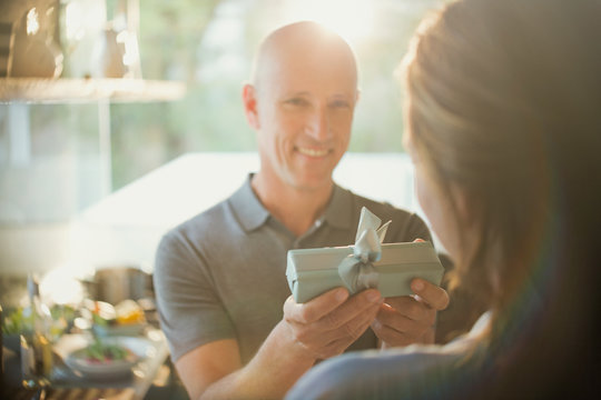 Smiling husband giving gift to wife