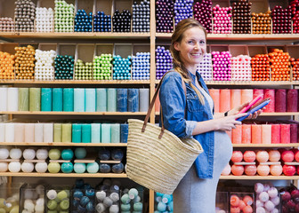 Portrait smiling pregnant woman shopping for candles in shop