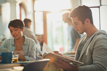 Young man college student reading book studying