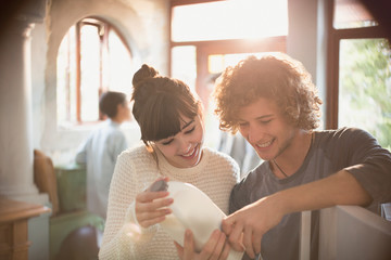 Young couple roommates looking at expiration date on milk in kitchen
