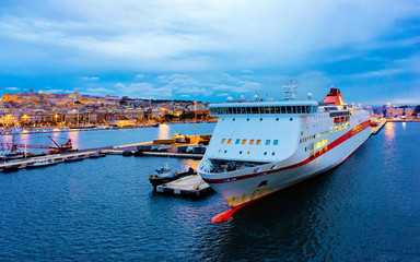 Naklejka premium Old Sardinian Port with ships at Mediterranean Sea and city of Cagliari, South Sardinia Island in Italy in summer. Cityscape with marina and Yachts and boats in town