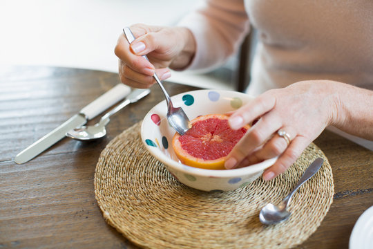 Woman Eating Grapefruit With Spoon