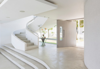 White foyer and spiral staircase in modern luxury home showcase interior