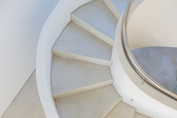 White, concrete spiral staircase in modern home showcase interior