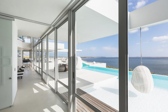 Modern luxury home showcase windows with infinity pool and ocean view