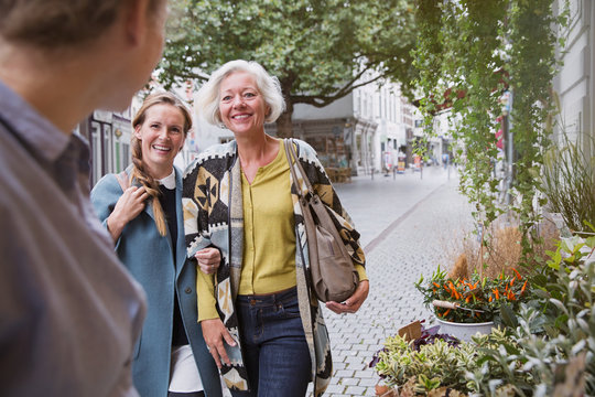 Mother and daughter smiling at florist at storefront