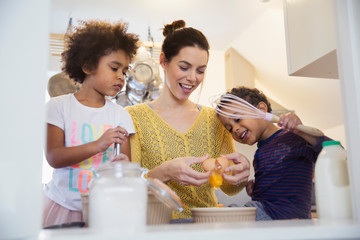 Mother and children baking in kitchen