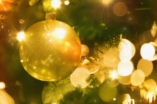 Close up golden ornament and string lights on Christmas tree