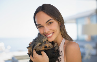 Portrait smiling woman cuddling small dog