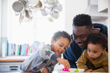 Happy father and sons playing with toys