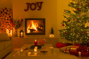 Ambient fireplace and candles in living room with Christmas tree