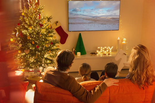 Family watching TV in Christmas living room