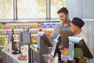 Cashiers working at grocery store checkout
