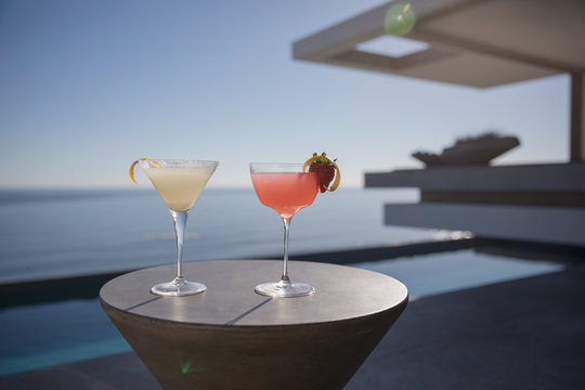 Cocktails in martini glasses on sunny luxury patio with sunny ocean view