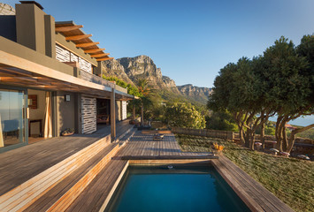 Mountains in background of luxury home showcase exterior house with swimming pool