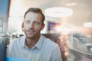 Businessman with headset working at computer in office