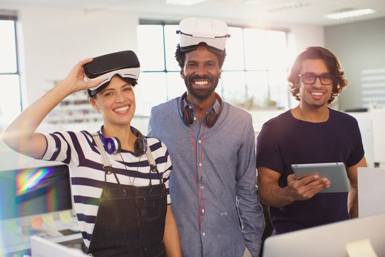 Portrait smiling, confident computer programmers testing virtual reality simulators in office