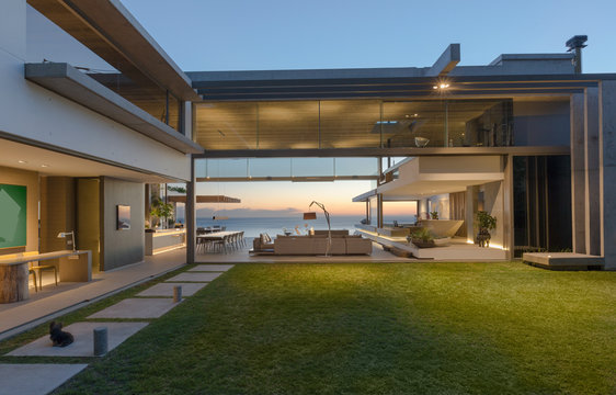 Illuminated modern, luxury home showcase courtyard and house