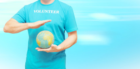 A man in a blue T-shirt with the inscription volunteer. The concept of volunteering around the world.