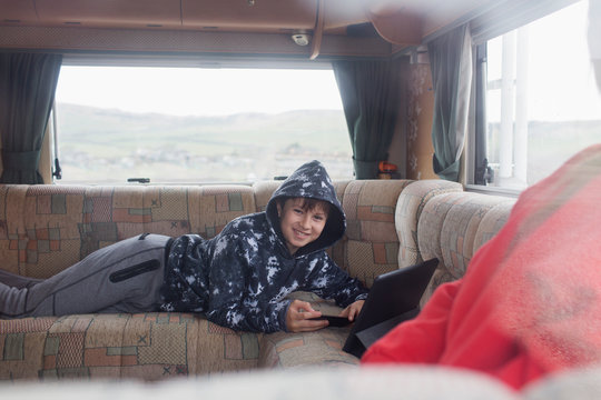 Portrait smiling boy using digital tablet in motor home