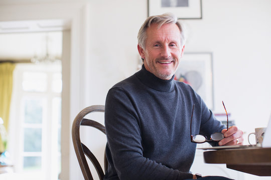 Portrait smiling mature man at dining table