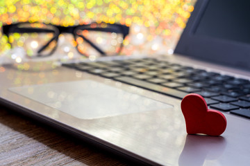 Online Dating concept with laptop red heart shape 