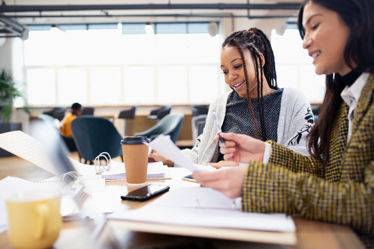 Businesswomen discussing paperwork in meeting